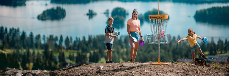 Familie spiller disc golf på bane